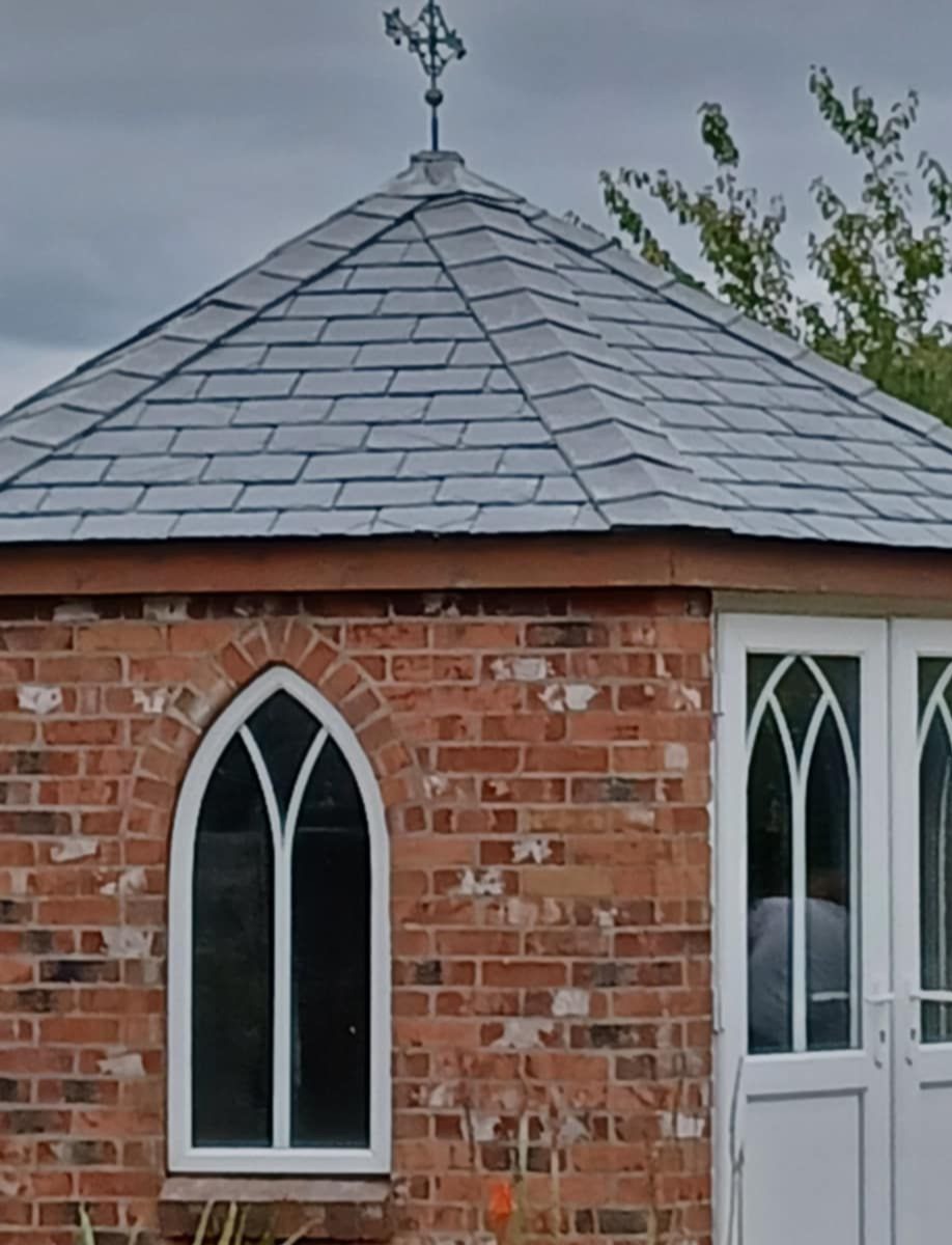 Close-up of new natural slate roof with weathervane finial
